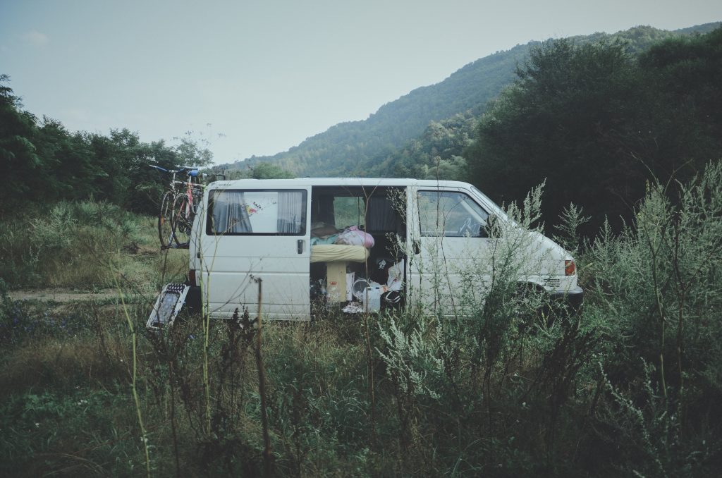 Un van blanc aménagé garé sur le bord d'une route de campagne